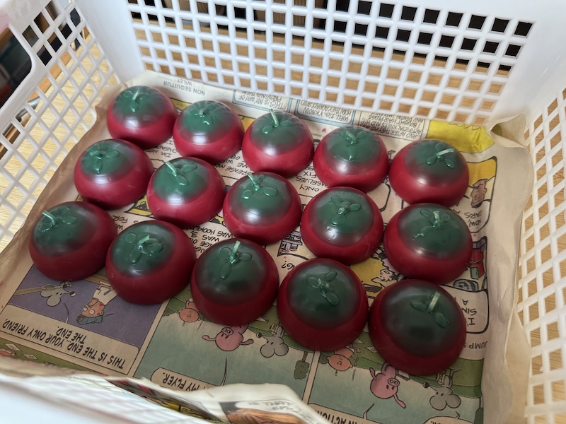 plastic basket/tray with 15 small half-sphere red candles that i dipped in green so they can kind of look like the top halves of plum tomatoes