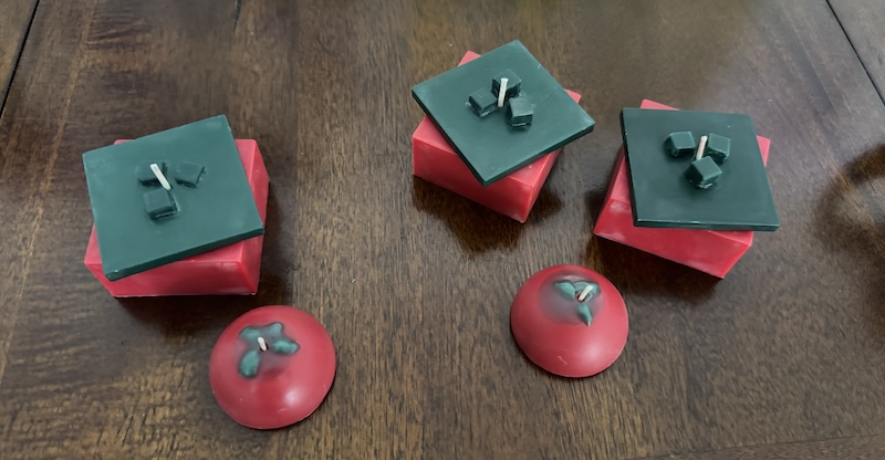 three of my handmade cubic/pixel art inspired tomato candles and 2 little round ones on a table, ready to be packed and shipped 