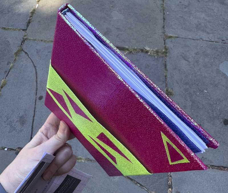 photo of the top view of my hardcover book, there’s a peek of the blue endpapers and little blue headband on the spine. it’s a pretty good job for my first one!