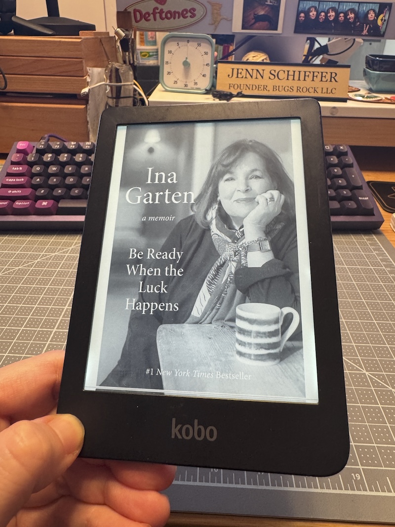 photo of me holding up my kobo e-book reader and it's got ina garten's "be ready when the luck happens" cover on it