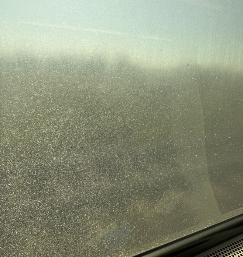 photo of an njtransit train window that's impossible to see anything except for the fact that it's bright outside