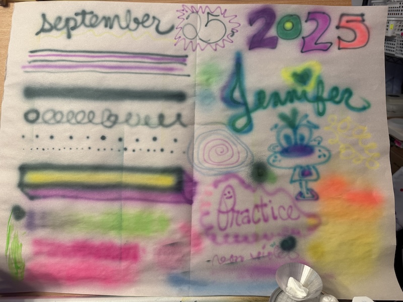 photo of my airbrush warmup newsprint. in different colors i wrote my name, the date, and a bunch of squiggles dots and shapes