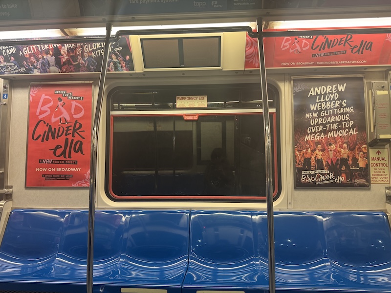 photo of an empty side of the path train car i was on that is plastered in posters of "bad cinderella"