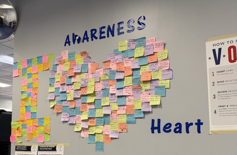 photo of the wall of the school i voted in that says "awarness" and then "i (heart shape)" which is made of post its and then "Heart"