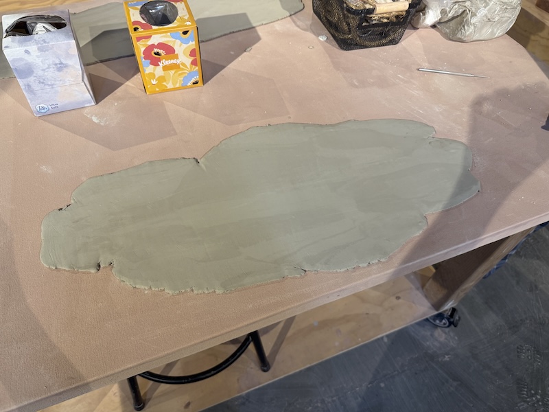 photo of a white clay slab on a table with some tissue boxes off to the side
