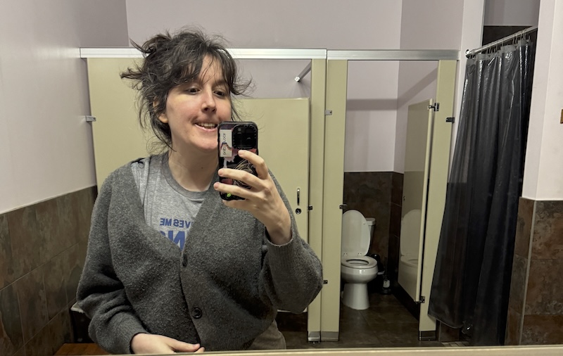 photo of me making a chipmunk face in the bathroom of my yoga studio that looks like it hasn't changed since the 90s - much like myself