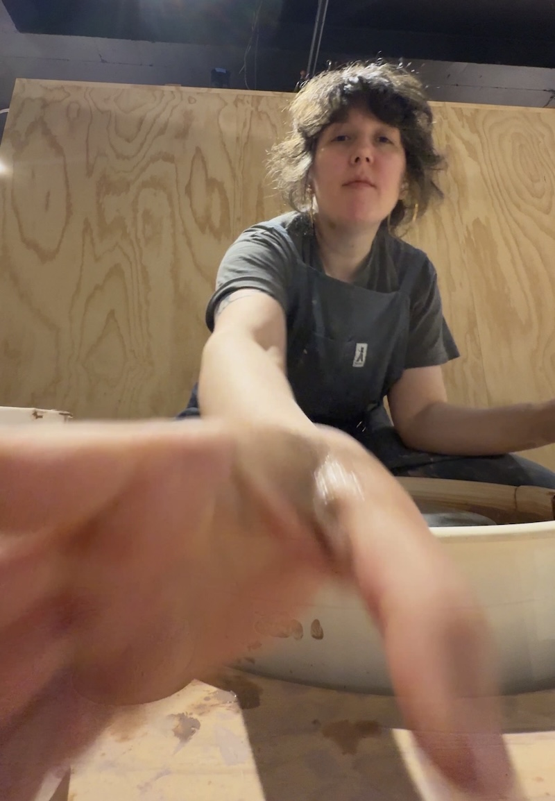 photo of me at the ceramics wheel and i am reaching for the phone with my hand so you can tell i'm bigger than a phone