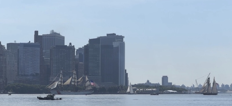 photo of the hudson river from the jersey city waterfront and there are some very old looking ships parading through on the manhattan side
