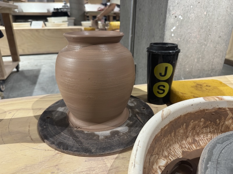 photo of a large vase i threw in two pieces and stacked on a bat next to my brooklyn js thermos and messy wheel station