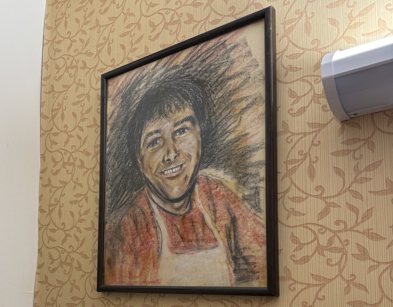 photo of a large, framed charcoal portrait of my dad when he was in his 30s