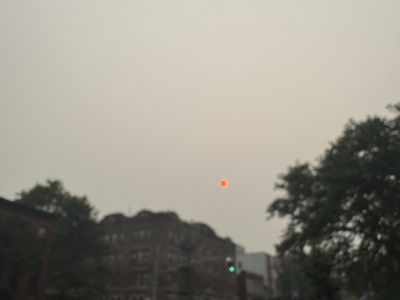 photo of a smoky hazy sky in brooklyn and the sun is neon orange