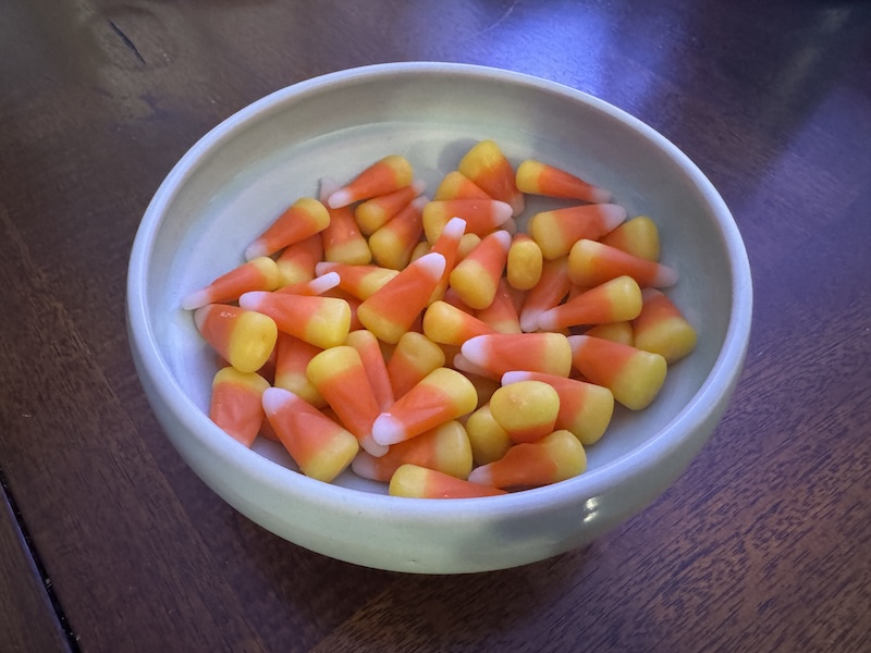 a photo of a delicate tiffany blue ceramic bowl full of candy corn