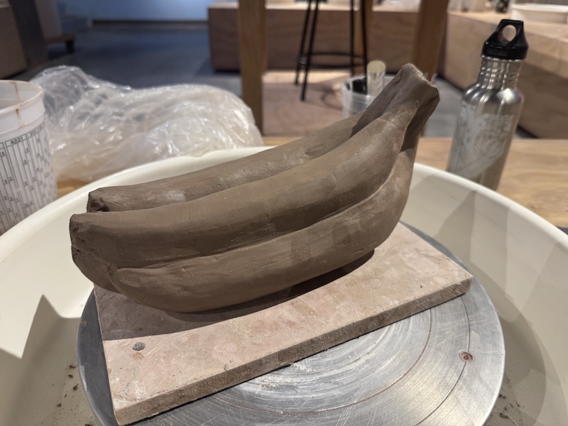 a photo of a clay bunch of bananas i'm carving in the studio