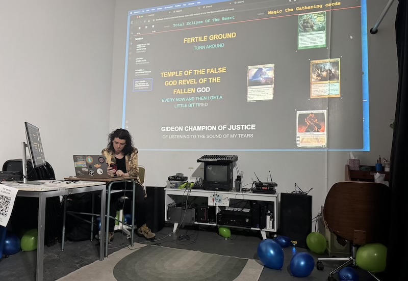 photo of jamie setting up our karaoke show, testing "total eclipse of the heart" as the tune with lyrics from magic the gathering cards