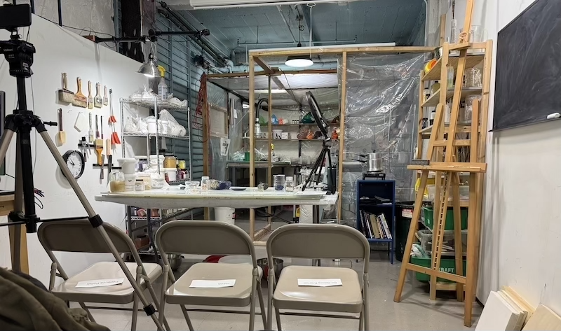 photo of the basement of kremer pigments, set up for a gesso workshop. no one is sitting in the reserved front row yet but you can see a reserved sign for the founder, dr. kremer