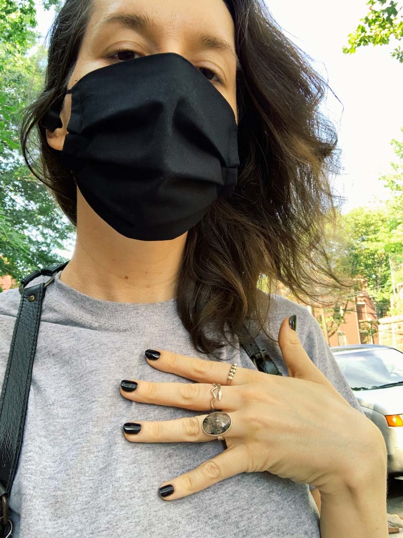 a photo of me outside with a black mask on, gray t-shirt and black nails freshly painted